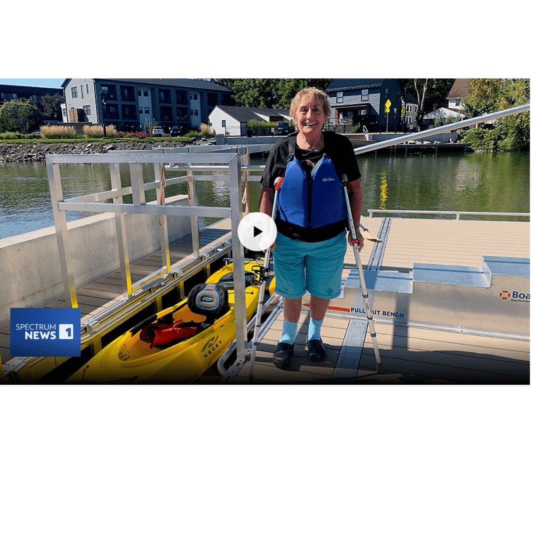 A screenshot of a news web article with woman with crutches on an adaptive kayak launch ready to enter a yellow kayak.