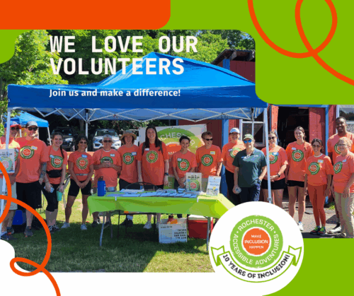A graphic stating We Love Our Volunteers with a photo of a line of people wearing RAA's orange shirt with round logo most standing under a blue tent outdoors in the sun
