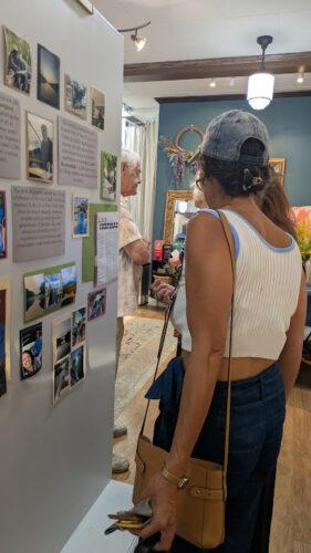 A person reading art descriptions on a moveable wall in an art studio