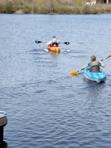 Two people in kayaks launch out on the Hudson River at Hudson Crossing Park.