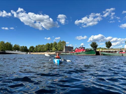 A panoramic view shows the variety of vessels lining the waterway along this section of the river.